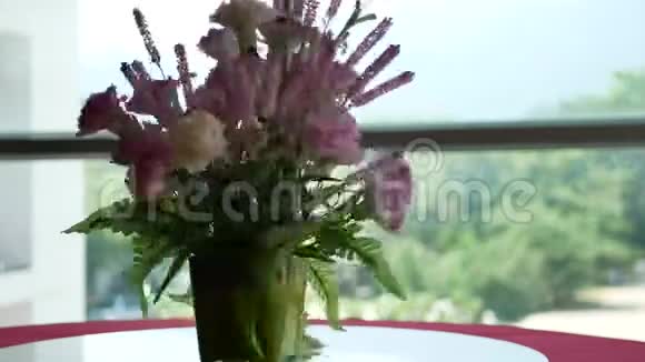 窗户旁边旋转桌子上花瓶里的花视频的预览图