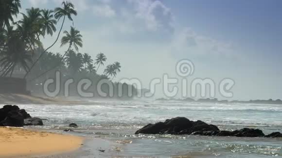波涛汹涌的海浪在蓝天下的沙滩上翻滚视频的预览图