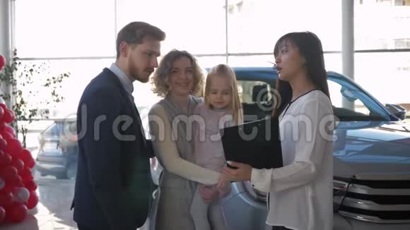 购买汽车有小孩的幸福夫妻向汽车顾问介绍购买家庭汽车的销售情况视频的预览图