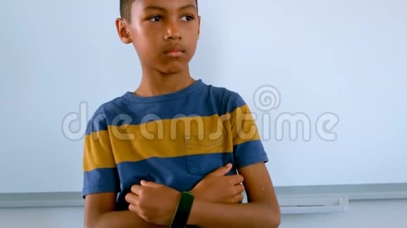 年轻的非裔美国男孩手拿下巴站在教室的白板上视频的预览图