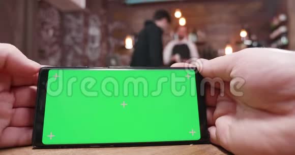在一家繁忙的餐馆咖啡店或酒吧里男人在绿色屏幕上刷卡视频的预览图