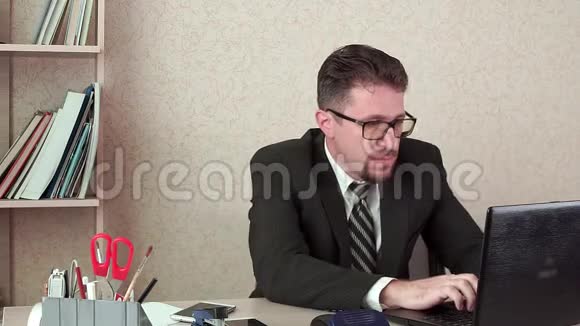 办公室经理胡须和眼镜男在笔记本电脑上工作视频的预览图