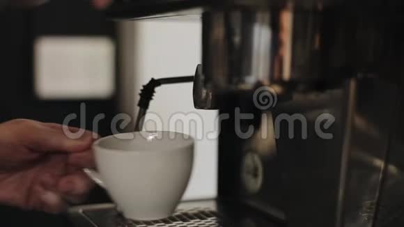 将专业咖啡机中的沸水倒入带有茶水的杯子中特写镜头视频的预览图