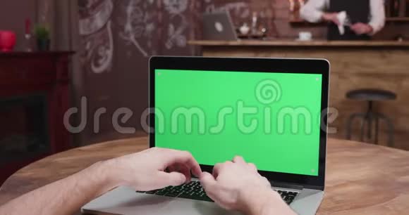 视差POV人在笔记本电脑上打字绿色屏幕打开视频的预览图
