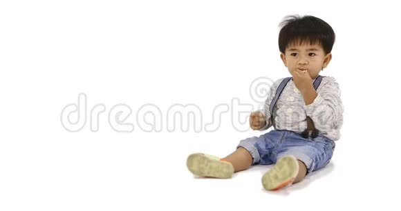 亚洲男孩坐在地上面前摆着一盘小吃视频的预览图