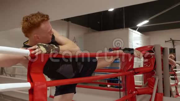 拳击手在拳击俱乐部的拳击训练前伸腿跆拳道训练伸展运动视频的预览图
