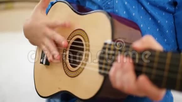 孩子拿着一把小吉他在上面弹音乐视频的预览图