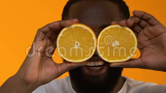 兴奋的黑人男子抱着新鲜的橙色半身被精力充沛的营养所震惊视频的预览图
