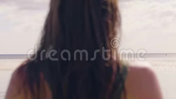 年轻女子穿着夏季比基尼在热带海滩后景的海水上散步游泳套房里游泳的苗条女人视频的预览图