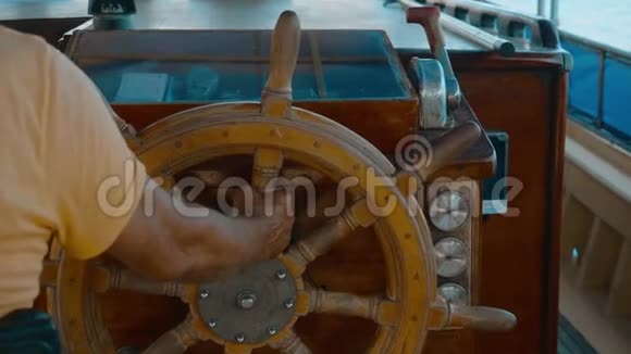 船长船在海上的帆船上持有方向盘在海上航行时男性手转动船舵视频的预览图