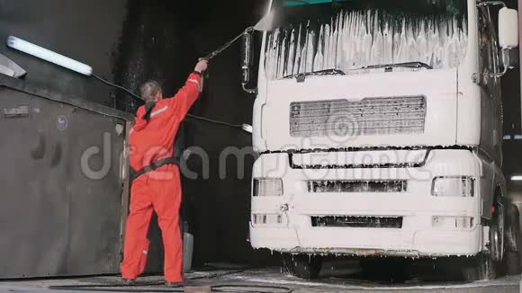 穿防护服的工人在慢行中用水清洗卡车视频的预览图