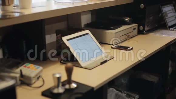 一个男收银员在咖啡店柜台后面用触摸板做的特写视频的预览图