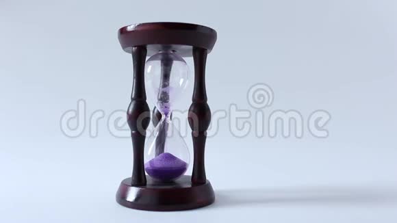 玻璃沙漏或鸡蛋计时器在白色背景与紫砂显示几乎结束的时间或时间视频的预览图