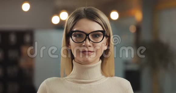 年轻成功的女商人戴着时尚眼镜看着相机站在办公室工作空间的肖像视频的预览图