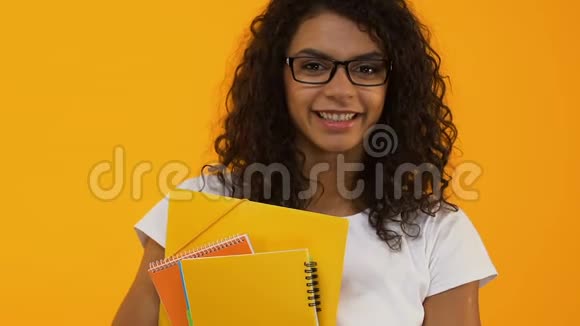 戴眼镜的聪明大学生拿着黄色背景的书受过教育视频的预览图