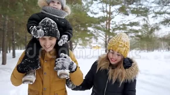 幸福的年轻一家人一起在冬季城市公园散步视频的预览图