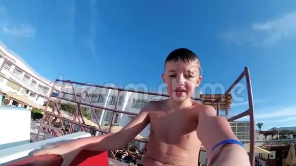 快乐男孩滑下一张水滑梯在埃及的一家酒店和自己自拍慢动作视频的预览图