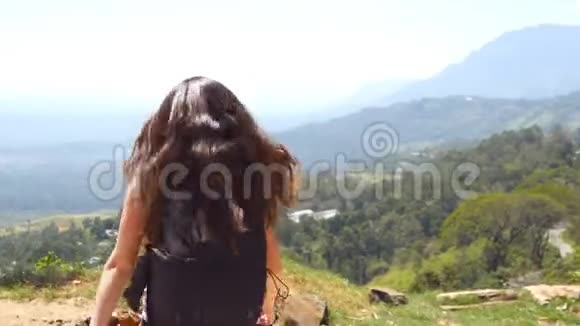 女游客跑到美丽的峡谷边缘胜利地伸出手臂向上年轻的女徒步旅行者视频的预览图