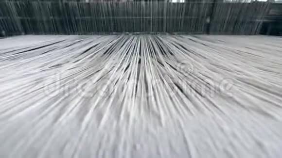 工业纺织厂合上穿过织布机的粗白线视频的预览图