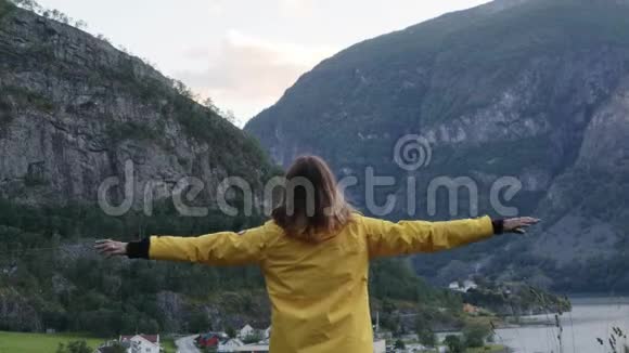 年轻女子站在山的边缘欣赏山顶视频的预览图