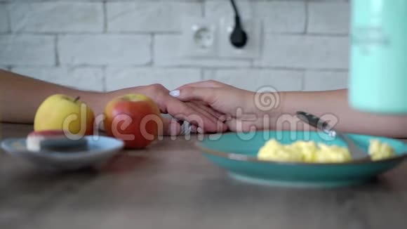 男人和女人在早餐桌旁牵手视频的预览图