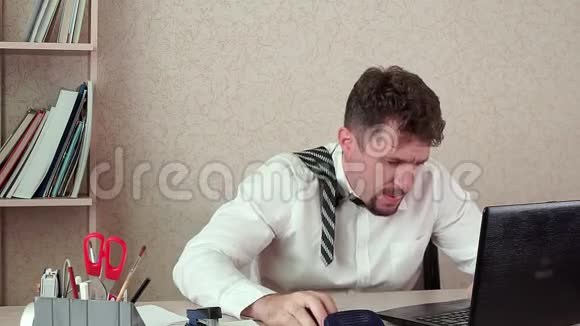 一个留胡子的人的办公室经理厌倦了工作骂着笔记本电脑视频的预览图