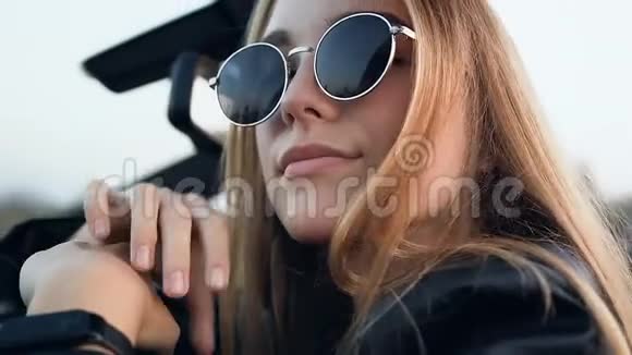 自信的金发女人坐在车里视频的预览图