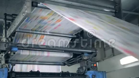 出版社单位用纸张通过机器滚动印刷报纸的排版视频的预览图
