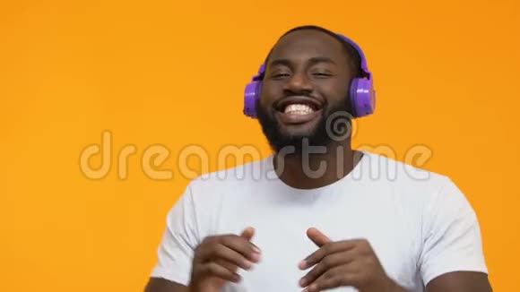 快乐的美国黑人男性在无线耳机享受电台热舞视频的预览图