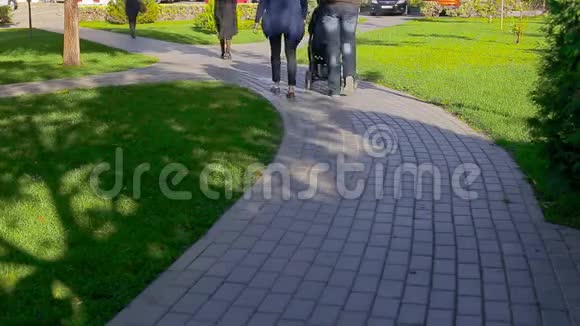 铺板的小径在城市画报公园里用绿色草坪特写步行者的脚视频的预览图