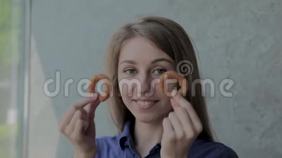 女孩带着洋葱圈到她的脸上在一家快餐店微笑视频的预览图