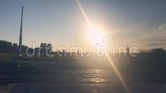 太阳落山在村里的铁路交叉路口铁路水平交叉视频的预览图