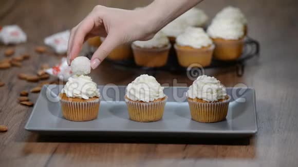 新鲜出炉的香草小蛋糕加椰子糖霜用椰松露装饰纸杯蛋糕视频的预览图