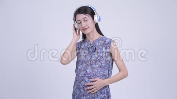 快乐的亚洲孕妇听音乐视频的预览图