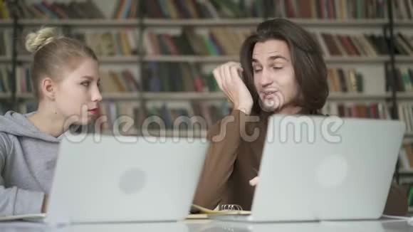 两个年轻的学生友好的男女有一个达洛在图书馆视频的预览图