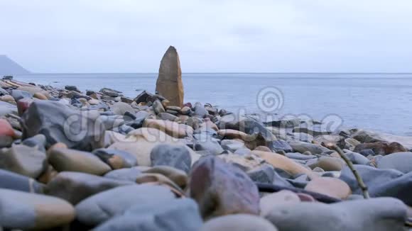 大自然的背景有一大块岩石在海上野生海滩的石头视频的预览图