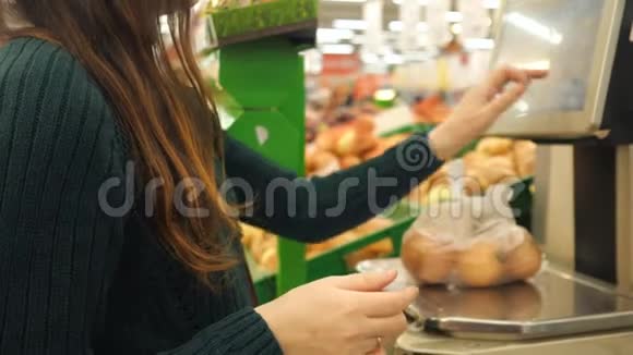 无法辨认的女人在杂货店用塑料袋秤重土豆视频的预览图