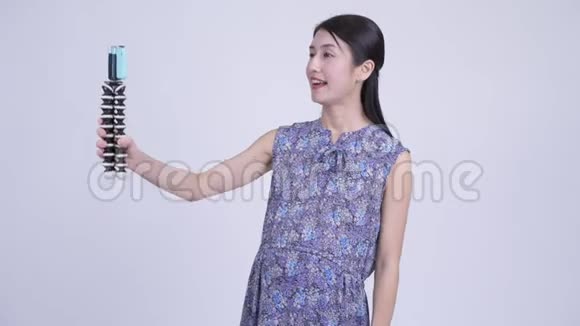 快乐的亚洲孕妇用电话视频的预览图