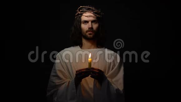 戴着荆棘王冠的圣斗士拿着蜡烛望着拍摄基督教视频的预览图