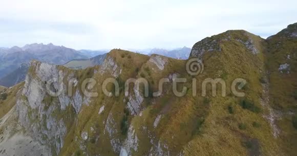 4k无人驾驶飞机向瑞士阿尔卑斯山悬崖边行走的人射击视频的预览图