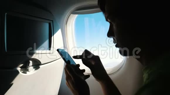旅游人士浏览移动电话触摸屏幕飞机旅行视频的预览图
