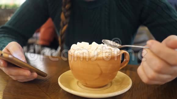 有电话的女孩喝咖啡吃棉花糖视频的预览图
