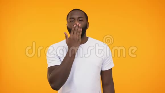 英俊的非裔美国人在镜头上送空气吻在黄色上隔离视频的预览图