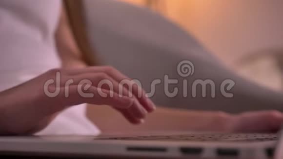 在舒适的家庭室内女性手在笔记本电脑上打字的特写镜头模糊和重新确定目标视频的预览图