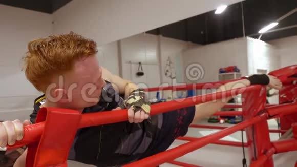 拳击手在搏击俱乐部比赛前伸腿拳击手在拳击时进行腿部伸展运动视频的预览图