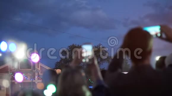 人们在智能手机上拍摄街头音乐会视频的预览图