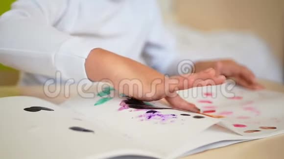幼儿用手指拿颜料画在狐狸纸上孩子们的手特写a的发展视频的预览图