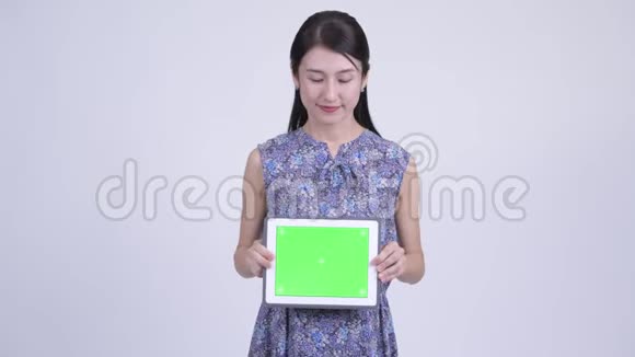 快乐怀孕的亚洲女性在展示数码平板电脑时的思考视频的预览图