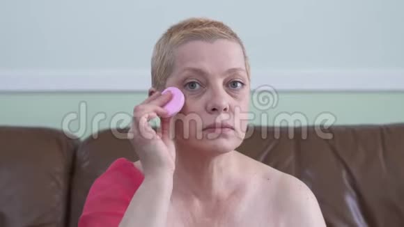 肖像成熟的女人在家里用棉垫水疗和护理清洁面部干净的脸视频的预览图