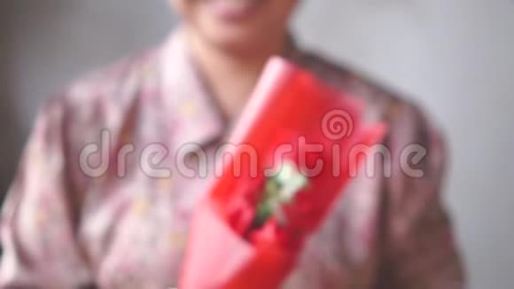 亚洲小姐微笑着给你一束红玫瑰慢动作视频的预览图